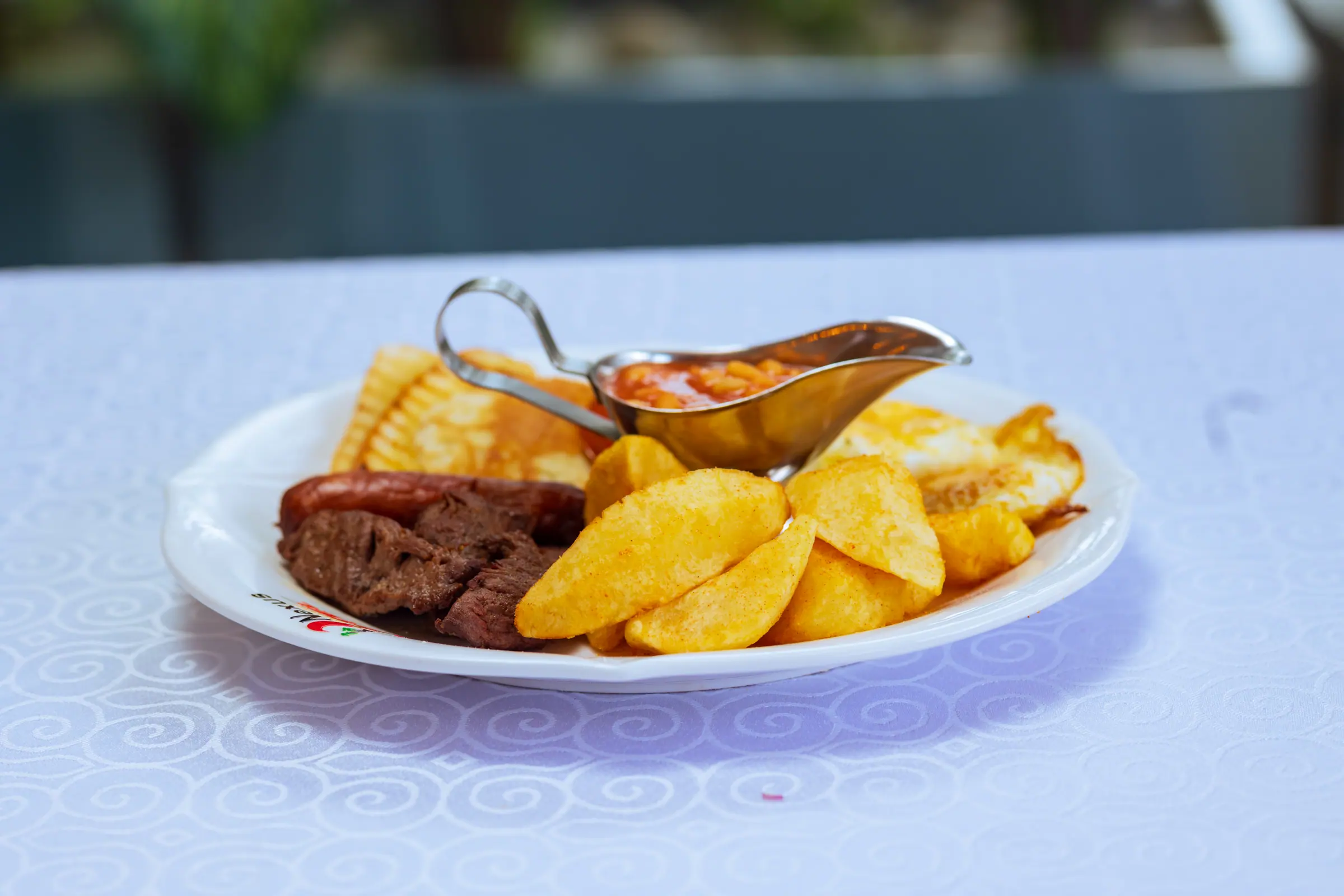 Grilled steak served with potato wedges and sauce