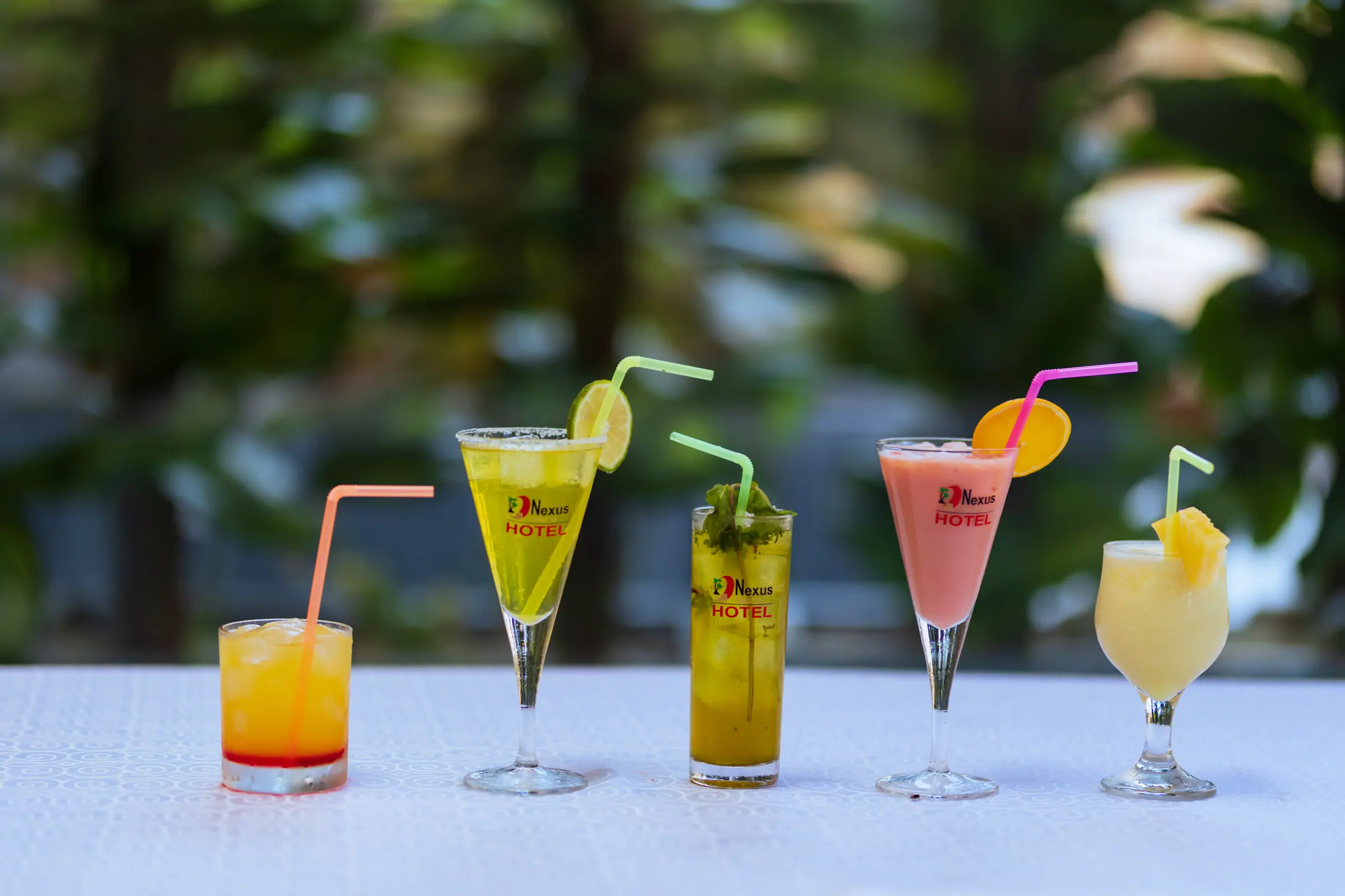 Cocktails and fresh juices lined up on a table outdoors